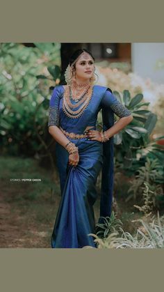 a woman wearing a blue sari and jewelry