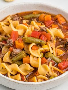 a white bowl filled with pasta and vegetables