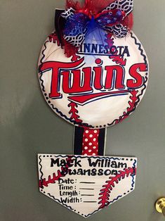 a baseball themed door hanger with the name twins on it