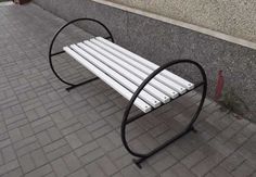 a white bench sitting on top of a sidewalk