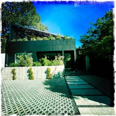 a building with many plants growing on the side of it and trees in the background