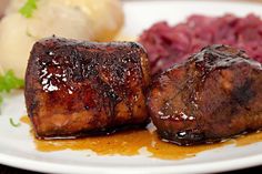 two pieces of meat sitting on top of a white plate