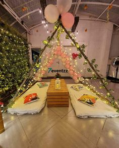 two beds with pillows and balloons on them in a room decorated for a baby's first birthday