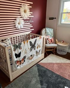 a baby's room with a crib, rocking chair and wall art on the walls