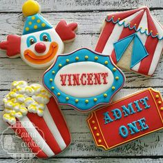 decorated cookies with circus theme and name on wooden table top, including one clown face