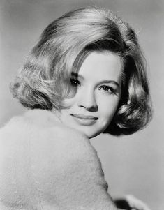 an old black and white photo of a woman with blonde hair, wearing a sweater