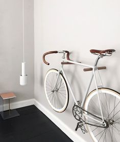 a white bicycle mounted to the side of a wall