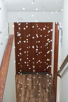 an overhead view of a hallway with wooden floors and white balls hanging from the ceiling