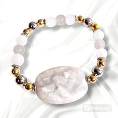 Beautiful white agate stone surrounded by silver and gold metal beads with clear white and gray glass beads. This stretch bracelet is 7-inches Silver Agate Stretch Bracelet, Elegant White Agate Crystal Bracelet, Adjustable White Agate Bracelets, White Adjustable Agate Bracelets, Silver Agate Stretch Bracelet With Natural Stones, White Stretch Bracelet With Silver Beads As Gift, White Agate Spiritual Stretch Bracelet, Adjustable White Agate Stretch Bracelet, White Adjustable Agate Stretch Bracelet