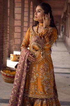 Bridal Yellow Lehenga Sharara Pakistani Wedding Dresses is a three-piece dress, paired with a long trailing veil along, a mustard yellow raw silk fabric kameez; revitalizing the whole attire to a whole new royalty. Yellow Lehenga Shirt: It is our marigold yellow ensemble that will be an absolute treat to the eyes and will lend you that perfect festive look. The shirt is adorned with interacted metallic embroidery featuring floral motifs and sweeping archway patterns taking inspiration from Mugha Mayun Dresses Pakistani, Yellow Mehndi Outfit, Mehndi Gharara, Yellow Gharara, Pakistani Mehndi Dress, Bridal Sharara, Mehndi Outfit, Suzuki Bikes, Mehndi Dresses