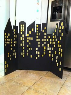 a black and yellow cityscape is displayed on the floor in front of a refrigerator