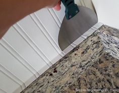 a person using a grater to clean granite counter tops