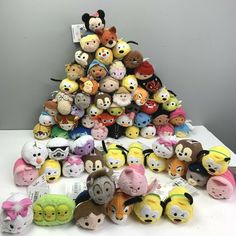 a pile of small stuffed animals sitting on top of a white table next to each other