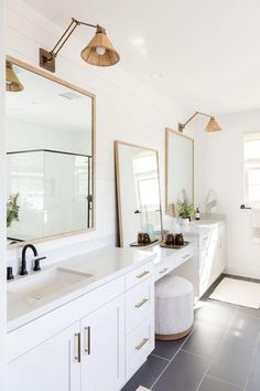 a white bathroom with two sinks and mirrors