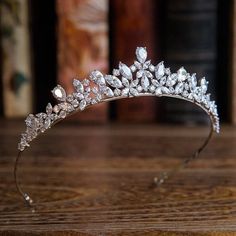 a tiara on a wooden table with books in the background