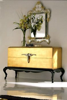 a dresser with flowers and a mirror on top