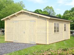 a large wooden shed sitting on top of a lush green field next to a stone walkway