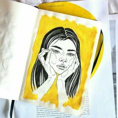 an open book with a drawing of a woman's face on the page and yellow background