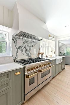 a kitchen with marble counter tops and stainless steel stove top ovens, along with wooden flooring