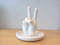 a white ceramic peace sign sitting on top of a wooden table