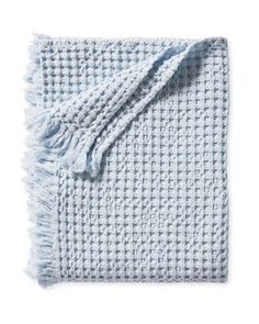 a blue and white blanket with fringes on it