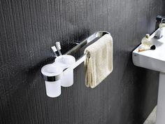 two toothbrushes, soap dispenser and towel hanging on the wall