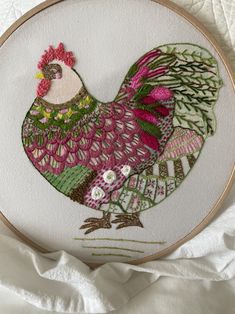 a close up of a embroidery on a piece of cloth with a rooster in the center