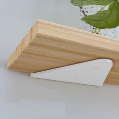 a close up of a wooden shelf with a remote control on it's side