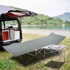 a camper van with its door open next to a picnic table