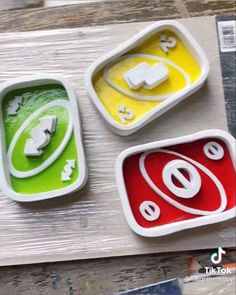 three different colored trays sitting on top of a wooden table next to each other