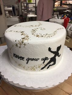 there is a white cake with gold sprinkles on it and the words never grow up