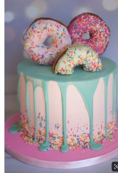 a cake with sprinkles and donuts on top