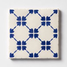 a blue and white tile with an intricate design on the bottom, against a white background