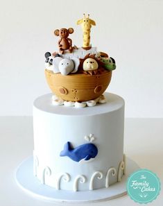 there is a cake decorated with animals in a boat on the top and bottom tier