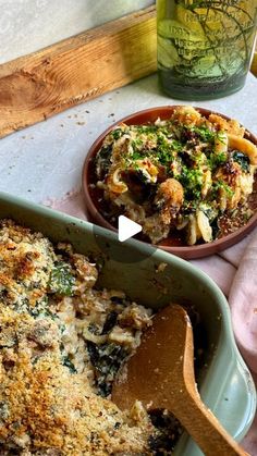 a casserole dish with broccoli and pasta in it next to a wooden spoon