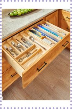 an open drawer with utensils and spoons in it on top of a counter