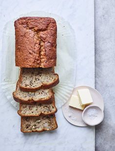 slices of banana bread stacked on top of each other next to butter and a knife