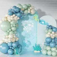 an under the sea balloon arch with blue and white balloons