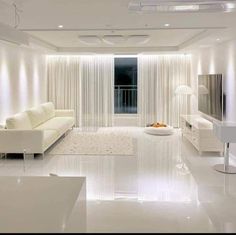 a living room with white furniture and curtains