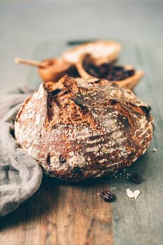 a sourdough sitting on top of a wooden table next to other breads