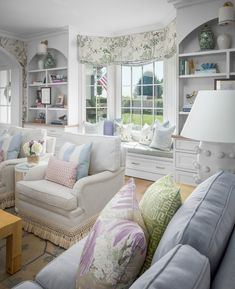 a living room filled with white furniture and lots of windows