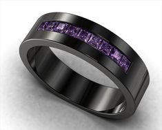 a black ring with purple stones in the center and channeled into each other's sides