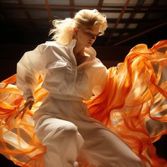 a woman with blonde hair is dancing in an orange and white dress