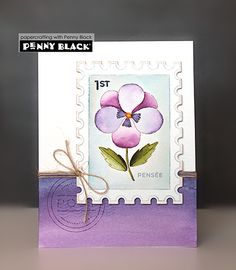 a stamp with a purple flower on it and a brown ribbon around the bottom corner