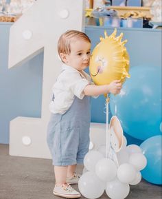 a little boy holding a balloon in his hand