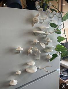 a white refrigerator covered in lots of different types of mushrooms on it's side