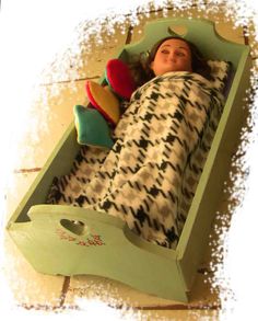 a doll is laying in a toy bed