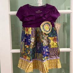 New Handmade Kids Size 4 T-Shirt Dress. The Fabric Motif Is Of Activities At A Fair. A Large Handcrafted Flower Was Placed On The Front Of The Bodice. A Ruffle And Ribbon Was Added To The Bottom Of The Dress. Casual Purple Patchwork Dress, Purple Patchwork Dress With Short Sleeves, Purple Short-sleeved Dress With Patchwork, Purple Short Sleeve Dress With Patchwork, Purple Patchwork Short Sleeve Top, Cute Purple Short Sleeve Dress, Amish Dress, Trolls Dress, Red Floral Sundress