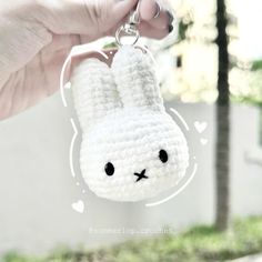 a crocheted bunny keychain is being held by someone's hand