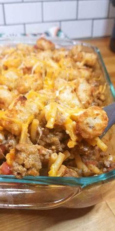 a casserole dish with meat and cheese in it sitting on a wooden table